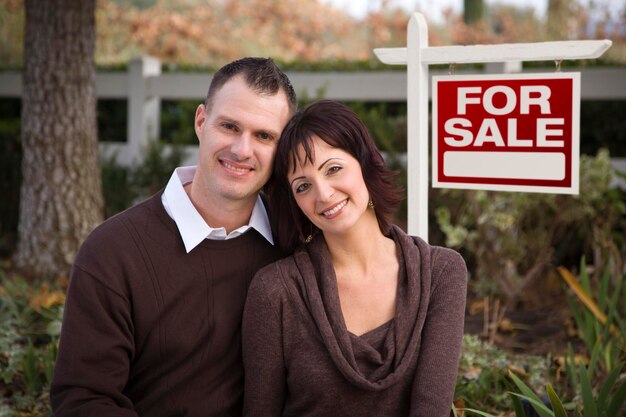 Happy Couple in Front of Real Estate Sign