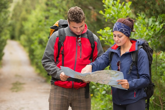 Happy couple going on hike together looking at map