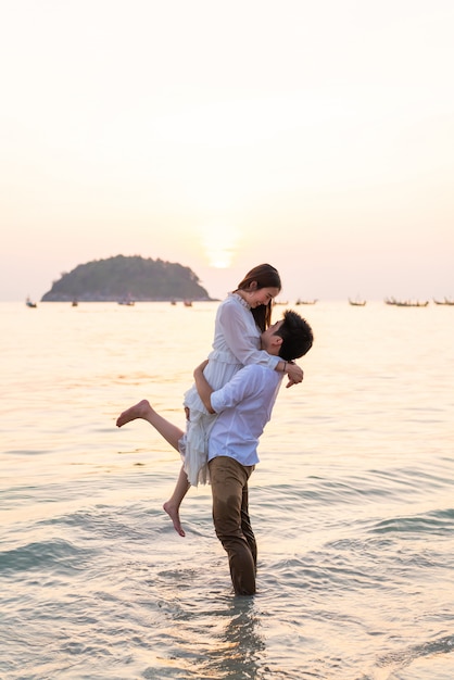 Happy couple going honeymoon travel on tropical sand beach in summer