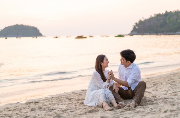 Happy couple going honeymoon travel on tropical sand beach in summer