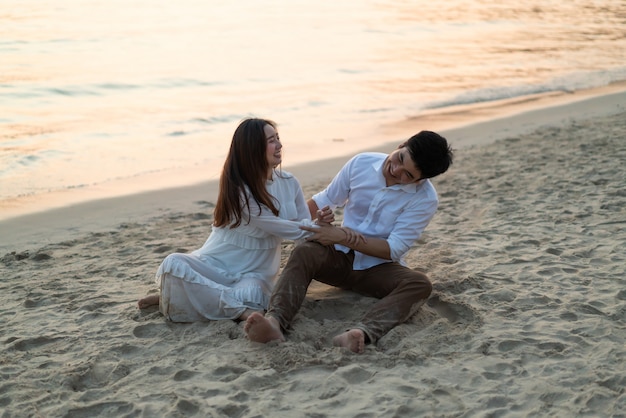 Happy couple going honeymoon travel on tropical sand beach in summer