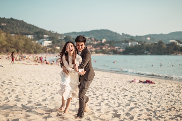 Happy couple going honeymoon travel on tropical sand beach in summer