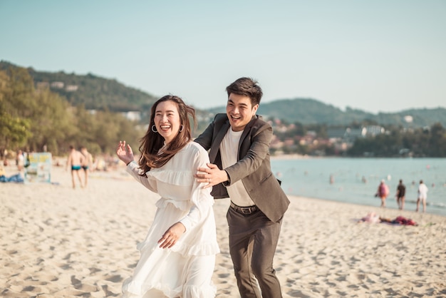 Happy couple going honeymoon travel on tropical sand beach in summer