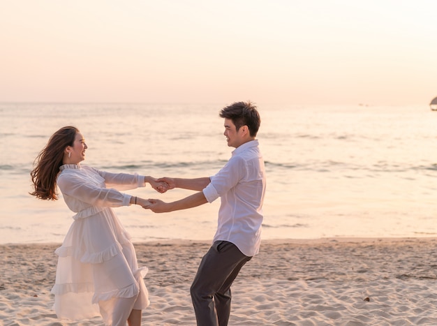 Happy couple going honeymoon travel on tropical sand beach in summer