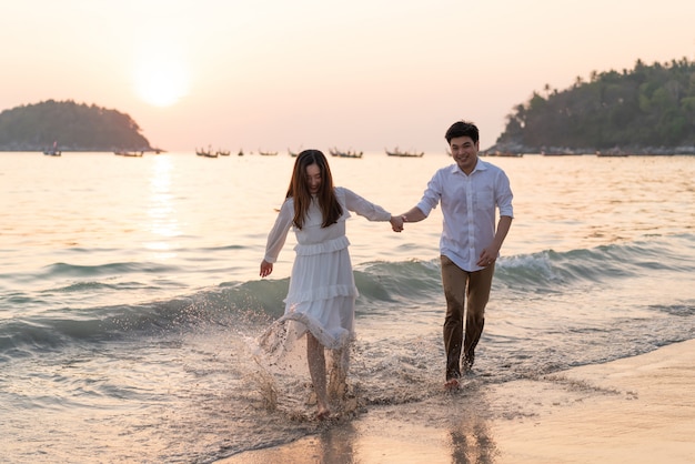 Happy couple going honeymoon travel on tropical sand beach in summer