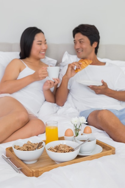 ベッドで朝食をする幸せなカップル