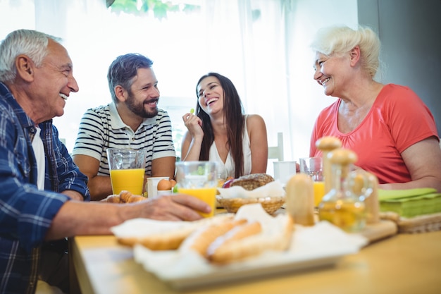 Happy couple having breakfast with their parents