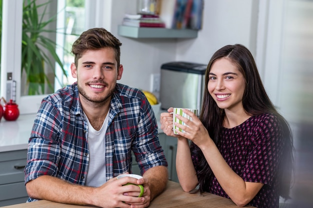 Happy couple having coffee together at home