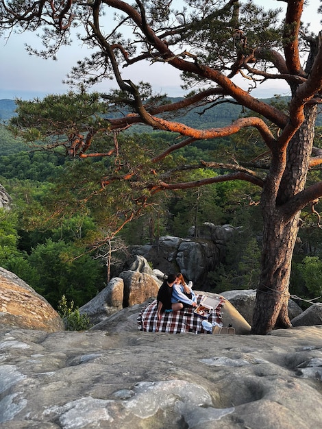 Happy couple having date at the cliff on sunset