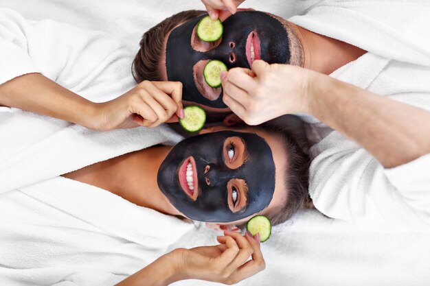 happy couple having facial in spa salon