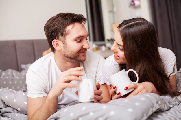 Happy couple having fun in bed. Intimate sensual young couple in bedroom enjoying each other.