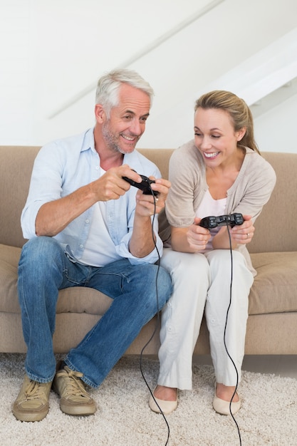 Happy couple having fun on the couch playing video games