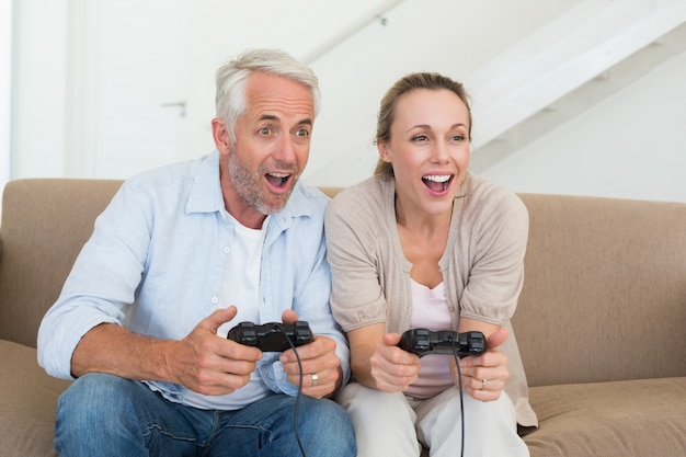 Happy couple having fun on the couch playing video games