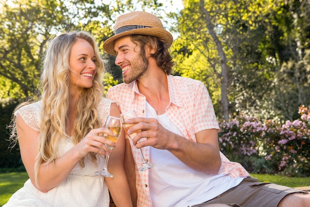 Happy couple having a picnic and drink champagne in the garden