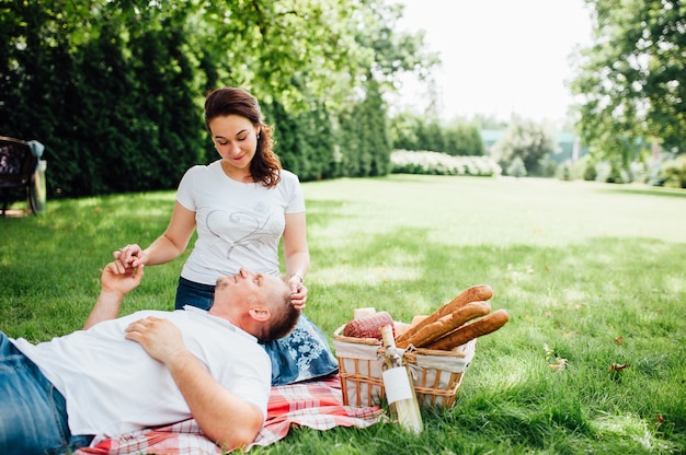 外で一緒にピクニックを持っている幸せなカップル