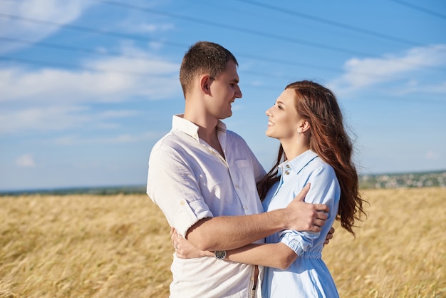 happy couple holding eachother in a wheat field