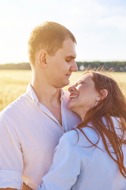 happy couple holding eachother in a wheat field