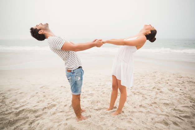 Happy couple holding hands on the beach