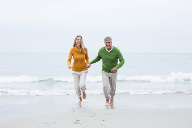 Happy couple holding hands and running