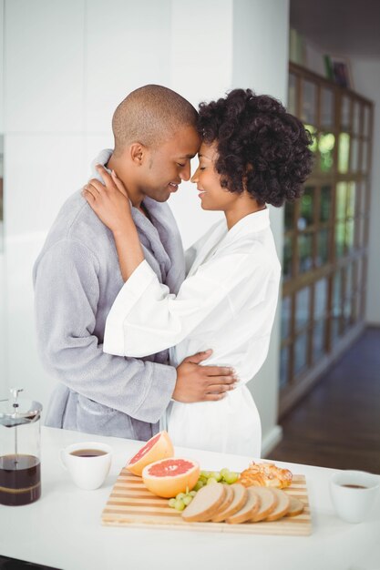 Happy couple hugging in the kitchen at home