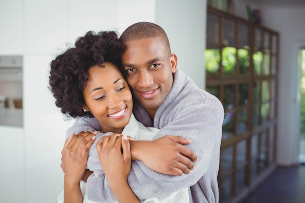 Happy couple hugging in the kitchen at home