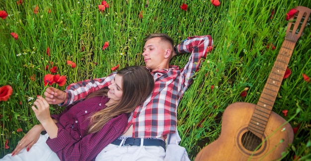 Фото Счастливая пара в маковом поле, обнимающая романтические отношения