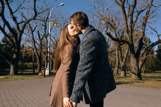 Happy couple kissing in an autumn park