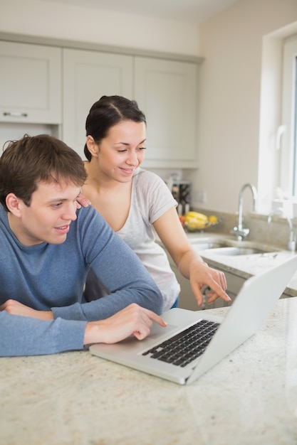 Happy couple looking at laptop