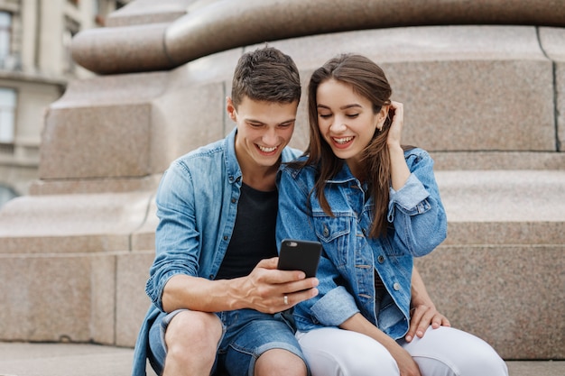 Photo happy couple looking at the phone