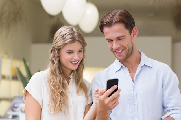 A happy couple looking at smartphone