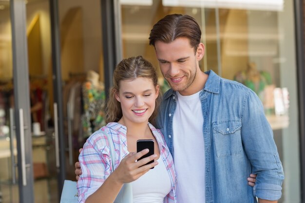 Happy couple looking at smartphone