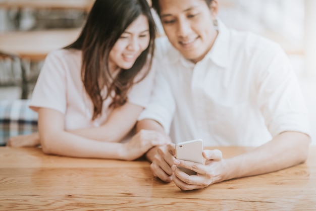 Happy couple looking on a smartphone 