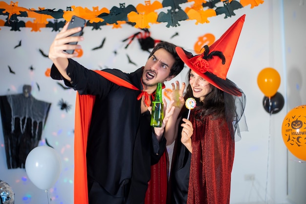 Happy couple of love in costumes and makeup on a celebration of Halloween