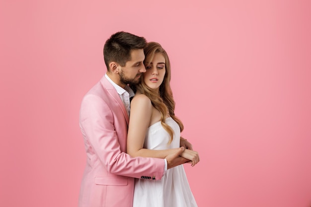 Happy couple in love embracing on pink background st valentines day