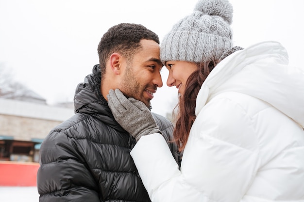 Coppie felici nell'amore che abbraccia all'aperto nell'inverno