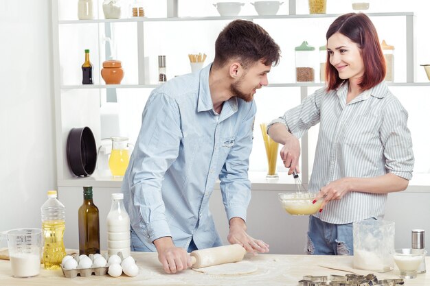 Happy Couple in love kneading dough in the kitchen