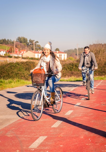 Happy couple in love riding bicycles by the nature on a sunny winter day