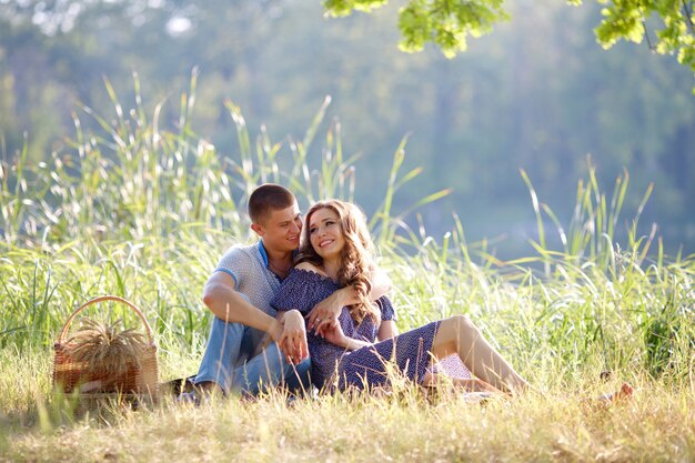 Счастливая пара в любви, сидя на праздничном пикнике на природе