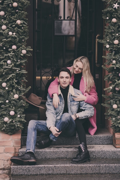 Happy couple in love sitting on stairs in city and smiling.