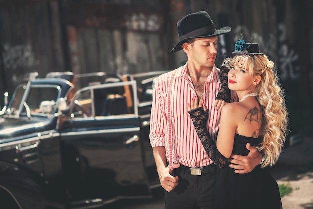 Photo happy couple in love standing near oldfashioned car