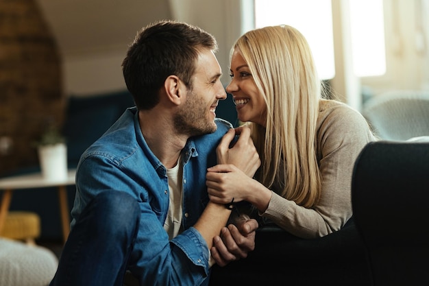 Coppia felice innamorata che parla faccia a faccia mentre ci si rilassa a casa