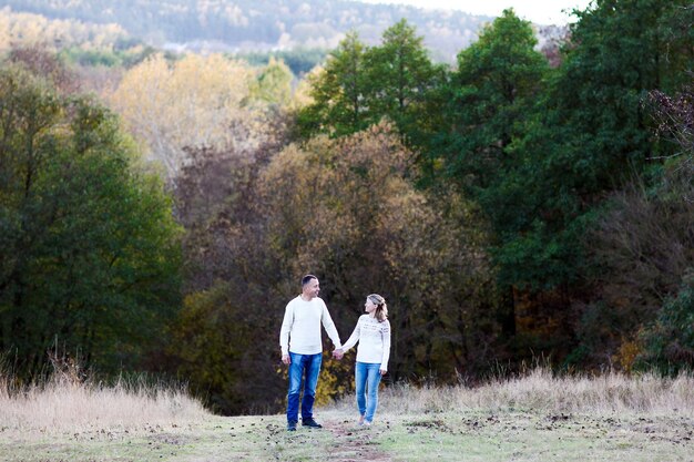 Photo happy couple in love walking in autumn park