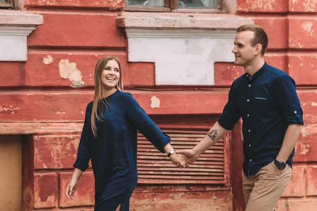 Happy couple in love walks the city streets together. A lovely couple on the old narrow streets of the city. Lifestyle of smiling people. Family relations concept