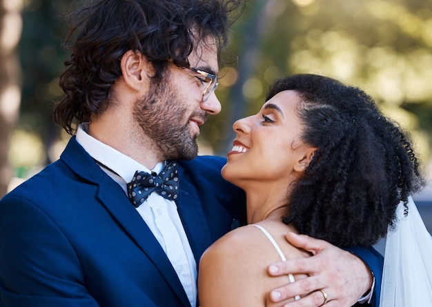 Photo happy couple love and wedding celebration event together with commitment care and support interracial man and woman at park with trust marriage partnership and a hug with a smile on their face