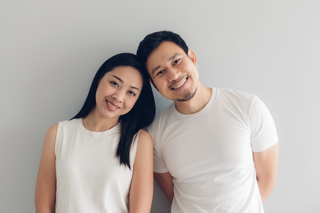 Photo happy couple lover in white t-shirt and grey background.