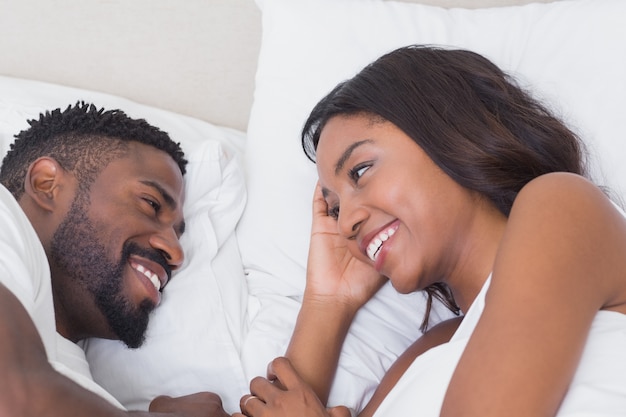 Happy couple lying in bed together