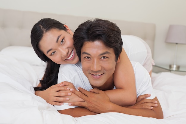 Happy couple lying on bed together