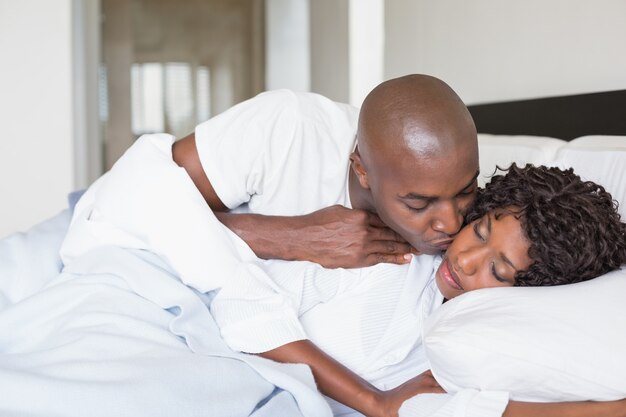 Happy couple lying in bed together 