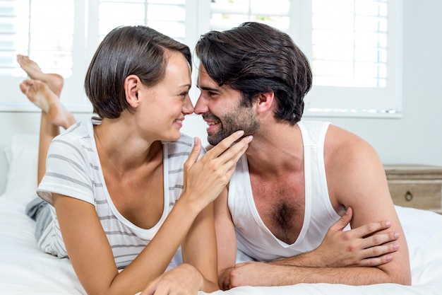 Happy couple lying on bed