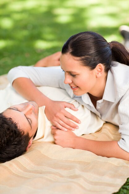 Happy couple lying down in the park